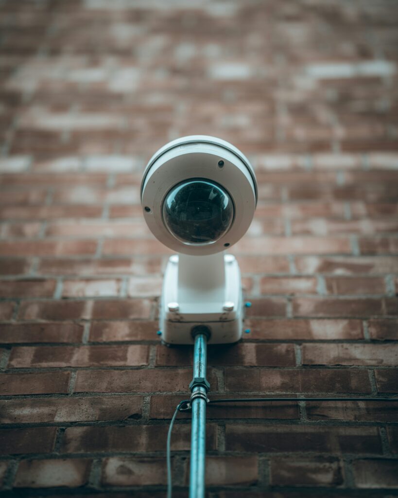 vit cctv kamera på tegelvägg